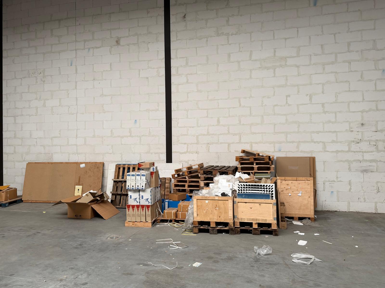 Magazijn vol archief en pallets, voor de bedrijfsontruiming